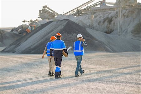 Three quarry workers, walking across quarry, rear view Stock Photo - Premium Royalty-Free, Code: 614-09056764