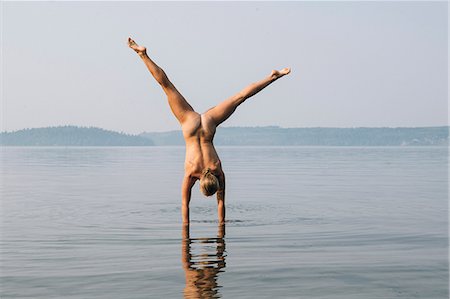 Rear view of nude woman doing handstand in water Stock Photo - Premium Royalty-Free, Code: 614-09056875