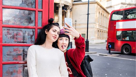 red call box - Two young stylish women taking smartphone selfie by red phone box, London, UK Stock Photo - Premium Royalty-Free, Code: 614-09057108