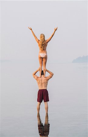 simsearch:633-01714467,k - Young couple on beach, woman standing on man's shoulders, rear view Stock Photo - Premium Royalty-Free, Code: 614-09057135