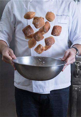 Cropped view of chef tossing doughnuts and sugar in mixing bowl Stock Photo - Premium Royalty-Free, Code: 614-09057178