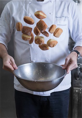 Cropped view of chef tossing doughnuts and sugar in mixing bowl Stock Photo - Premium Royalty-Free, Code: 614-09057179