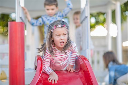 simsearch:649-07520254,k - Girl at preschool, lying at top of playground slide in garden Stock Photo - Premium Royalty-Free, Code: 614-09057258