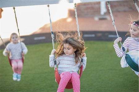 simsearch:649-07804176,k - Girls at preschool, swinging on playground swings in garden Stock Photo - Premium Royalty-Free, Code: 614-09057252