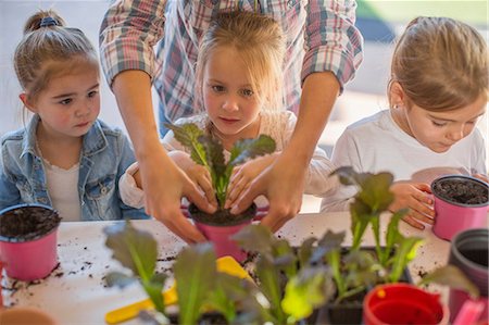 Mid adult woman helping young children with gardening activity Foto de stock - Sin royalties Premium, Código: 614-09057339