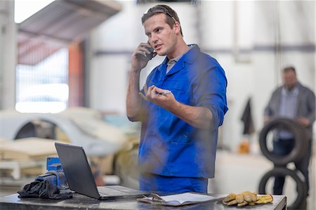 fixing - Car mechanic making smartphone call in repair garage Stock Photo - Premium Royalty-Free, Code: 614-09057409