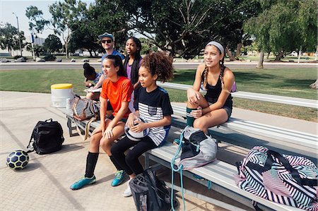 Male teacher and schoolgirls watching soccer practice on school sports field Stock Photo - Premium Royalty-Free, Code: 614-09078932