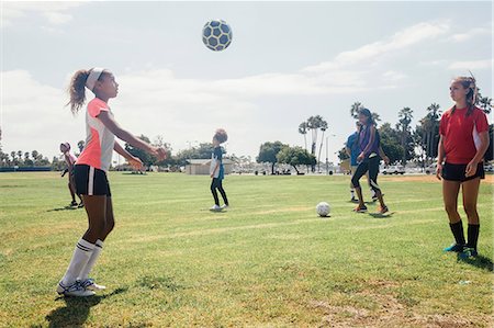 simsearch:614-08270379,k - Schoolgirls face to face kicking soccer ball to each other on school sports field Stock Photo - Premium Royalty-Free, Code: 614-09078957