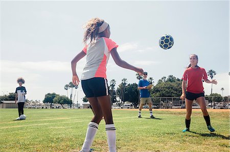 simsearch:614-08270379,k - Schoolgirls kicking ball to each other on school sports field Stock Photo - Premium Royalty-Free, Code: 614-09078960