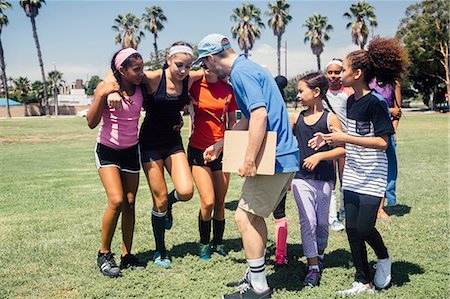 Schoolgirl soccer team and teacher supporting injured player on school sports field Photographie de stock - Premium Libres de Droits, Code: 614-09078977