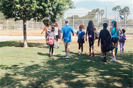simsearch:649-07280058,k - Rear view of teacher and schoolgirls walking to soccer practice on school sports field Stock Photo - Premium Royalty-Free, Code: 614-09079002