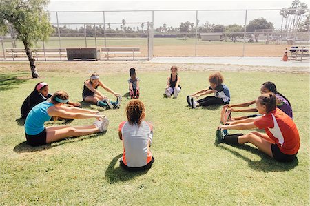 preteen girls stretching - Schoolgirl soccer players warming up in circle on school sports field Stock Photo - Premium Royalty-Free, Code: 614-09079021