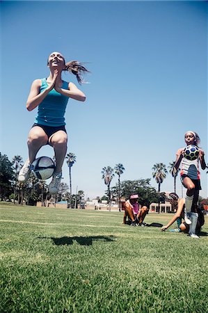 simsearch:649-07063753,k - Schoolgirl jumping with soccer ball on school sports field Stock Photo - Premium Royalty-Free, Code: 614-09079056
