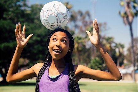 Teenage schoolgirl soccer player balancing ball on head on school sports field Stock Photo - Premium Royalty-Free, Code: 614-09079064