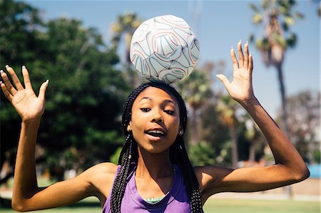 Teenage schoolgirl soccer player balancing ball on head on school sports field Stock Photo - Premium Royalty-Free, Code: 614-09079065