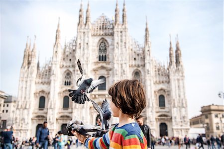 flying bird human hand - Boy feeding pigeons in Milan Cathedral square, Milan, Lombardy, Italy Stock Photo - Premium Royalty-Free, Code: 614-09110716
