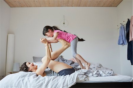 foot fun - Mother and daughter playing in bedroom, mother balancing daughter on feet Stock Photo - Premium Royalty-Free, Code: 614-09127336