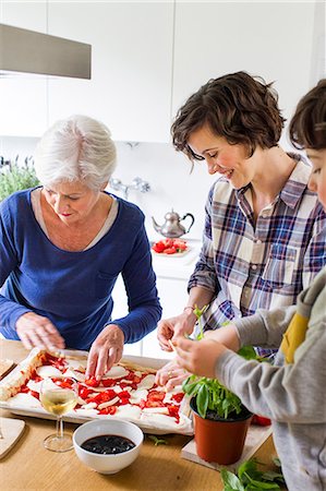 simsearch:649-07761247,k - Young boy, mother and grandmother making pizza together in kitchen Stock Photo - Premium Royalty-Free, Code: 614-09127390