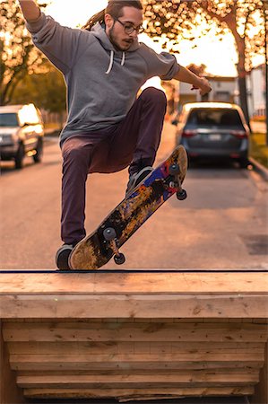 ramps on the road - Young male skateboarder turning on top of ramp on suburban street at sunset Foto de stock - Sin royalties Premium, Código: 614-09159594