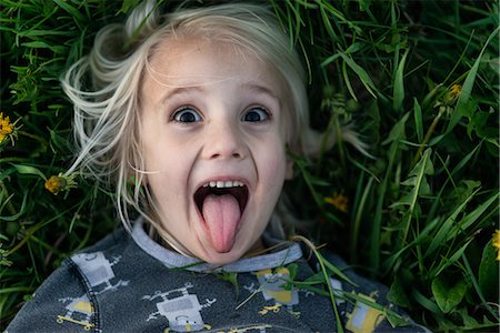 stick tongue out - Blond haired boy lying on grass sticking tongue out, portrait Stock Photo - Premium Royalty-Free, Code: 614-09159621