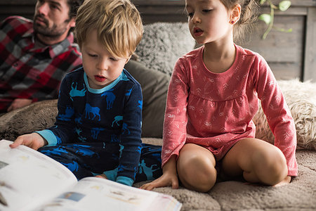 simsearch:632-03848361,k - Children reading book at home, father in background Stock Photo - Premium Royalty-Free, Code: 614-09178503