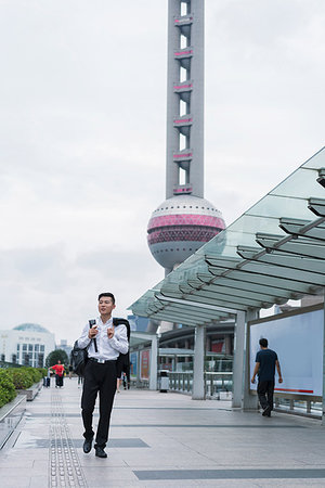Young businessman looking strolling in city, Shanghai, China Stock Photo - Premium Royalty-Free, Code: 614-09183102