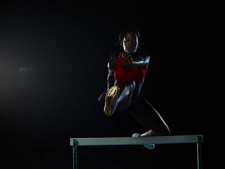 simsearch:614-06624830,k - Runner jumping over hurdle on track Stock Photo - Premium Royalty-Free, Code: 614-09209765