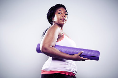 fat african american excercise - Mid adult woman holding yoga mat Stock Photo - Premium Royalty-Free, Code: 614-09209930