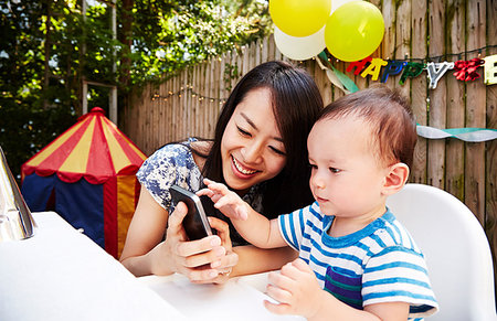 Mother and baby boy looking at smartphone Stock Photo - Premium Royalty-Free, Code: 614-09210447