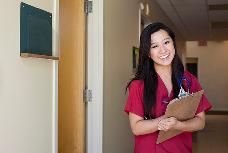 Portrait of young female nurse with clipboard Stock Photo - Premium Royalty-Free, Code: 614-09210512