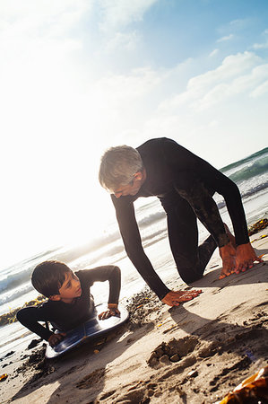 simsearch:649-07596731,k - Father and son practicing on surfboard at beach, Encinitas, California, USA Stock Photo - Premium Royalty-Free, Code: 614-09210695