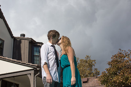 simsearch:649-07520320,k - Young couple kissing on suburban street Photographie de stock - Premium Libres de Droits, Code: 614-09210775