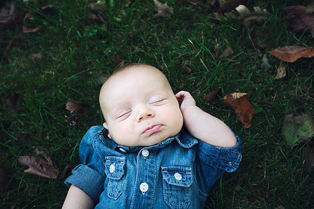 simsearch:614-07031850,k - Baby boy wearing denim shirt lying on autumn leaf covered grass eyes closed Stock Photo - Premium Royalty-Free, Code: 614-09212247