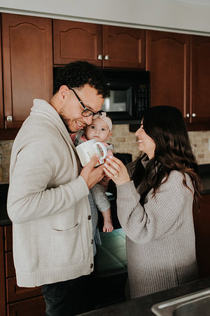 simsearch:700-01582158,k - Couple having drink and carrying baby daughter in kitchen Stock Photo - Premium Royalty-Free, Code: 614-09249555