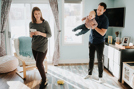 swinging (partner swapping) - Mid adult couple playing with baby son in living room Stock Photo - Premium Royalty-Free, Code: 614-09249679