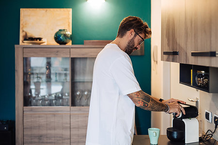 Mid adult man preparing coffee machine on kitchen counter Stock Photo - Premium Royalty-Free, Code: 614-09258502