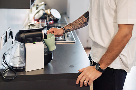 Mid adult man pouring coffee from coffee machine on kitchen counter, mid section Stock Photo - Premium Royalty-Free, Code: 614-09258510