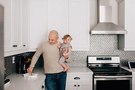 dad shave - Father carrying baby daughter in kitchen, portrait Stock Photo - Premium Royalty-Free, Code: 614-09258591