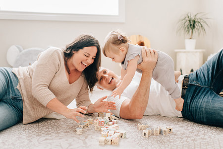 simsearch:614-06896477,k - Mother and father reclining on nursery floor playing with baby daughter Stock Photo - Premium Royalty-Free, Code: 614-09258622