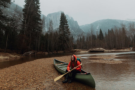 Happy young female canoeist sitting on canoe in river, Yosemite Village, California, USA Stock Photo - Premium Royalty-Free, Code: 614-09259101