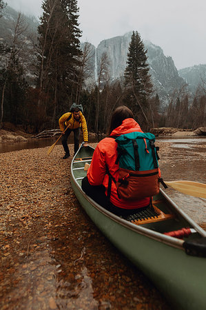 Young canoeing couple pushing off from riverbank, Yosemite Village, California, USA Stock Photo - Premium Royalty-Free, Code: 614-09259102