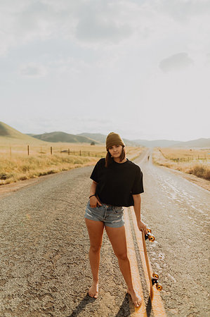 Young female skateboarder on rural road, portrait, Exeter, California, USA Stock Photo - Premium Royalty-Free, Code: 614-09259123