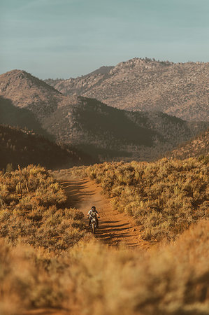 Motorbiker riding through landscape of Kennedy Meadows, California, US Photographie de stock - Premium Libres de Droits, Code: 614-09259142