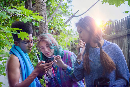 simsearch:614-06896861,k - Three male and female teenagers in garden looking at smartphone Stock Photo - Premium Royalty-Free, Code: 614-09253784