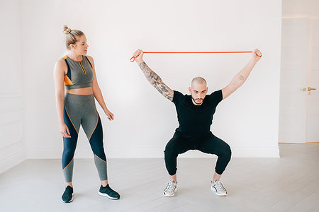 simsearch:6118-07731916,k - Woman observing fitness instructor using resistance band in studio Photographie de stock - Premium Libres de Droits, Code: 614-09276222