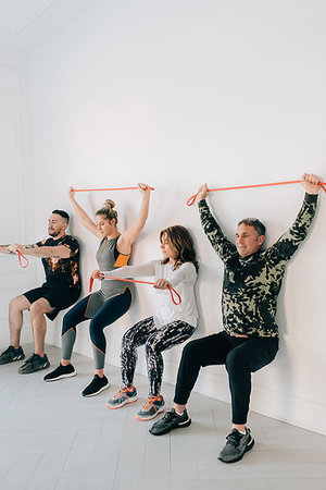 simsearch:6128-08825413,k - Friends doing squat against wall with resistance band Stock Photo - Premium Royalty-Free, Code: 614-09276230