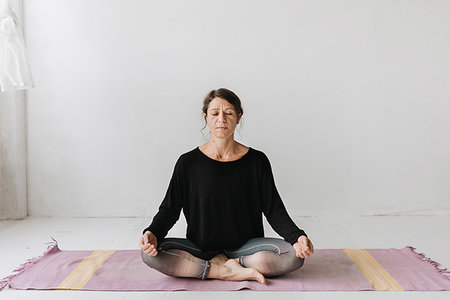 simsearch:6102-08942314,k - Woman sitting in lotus pose in yoga studio Photographie de stock - Premium Libres de Droits, Code: 614-09276293