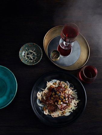 simsearch:6118-07808971,k - Rustic low key still life with bowl of grilled beef fillet, bitter lemon and black bean sauce on table, overhead view Stock Photo - Premium Royalty-Free, Code: 614-09276447