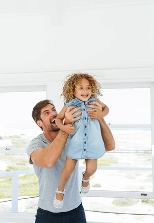 simsearch:614-08030822,k - Father lifting daughter in mid air in beach house Stock Photo - Premium Royalty-Free, Code: 614-09276852