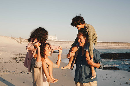 simsearch:649-07596731,k - Couple giving children piggyback ride on beach Stock Photo - Premium Royalty-Free, Code: 614-09276961